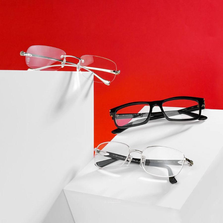 3 chiếc kính: 1 kim loại, 2 Acetate được trưng bày trên bàn trắng cùng background đỏ