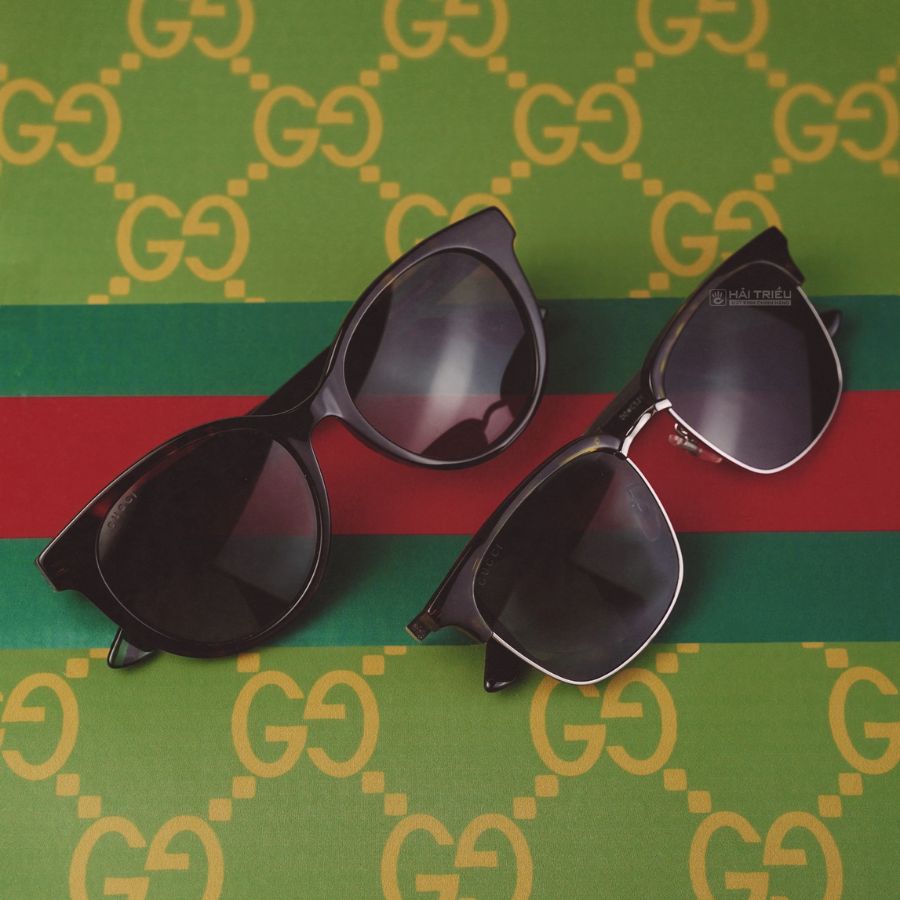 Hai chiếc kính râm đen đến từ thương hiệu Gucci đang được đặt trên tấm thảm đầy sang trọng