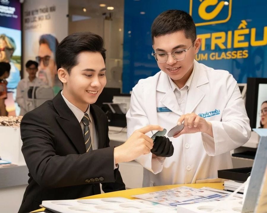 Hình ảnh khách hàng được chuyên viên tư vấn các tính năng của tròng kính chống ánh sáng xanh