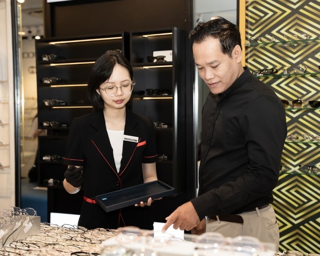 Không gian tư vấn và đo kính tại Kính Hải Triều, thể hiện quy trình đo mắt và thử form gọng đen trực tiếp